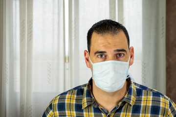 Man in checkered shirt and face mask posing