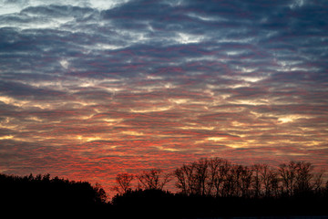 Spring sunset sky with clouds in red and blue
