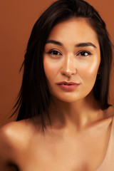Naklejka premium young pretty asian woman cheerful smiling posing on warm brown background, lifestyle people concept