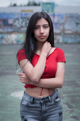 girl with long black hair in the middle of a basketball court with the background out of focus and her hand on her neck