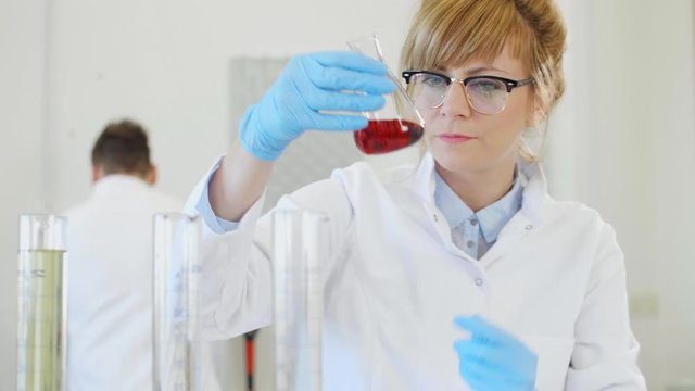 Chemist working with hemp CBD oil and tablet in laboratory