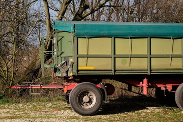 Grüner Anhänger mit Pritsche und Plane für die Ernte mit hoher Bordwand am Gut Barkhausen bei...