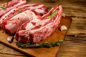Raw pork ribs with spices, garlic and rosemary on wooden table