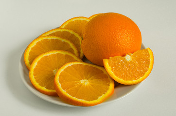 juicy oranges sliced on a plate on a white background