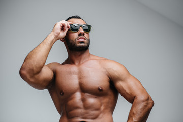 A sexy athlete with a naked torso is wearing glasses. Rest, healthy lifestyle