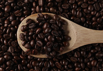 Coffee beans with wooden spoon background, top view