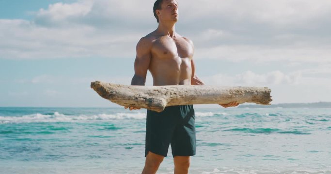 Strong athletic man working out with a beach log, weight lifter achieving his fitness goals
