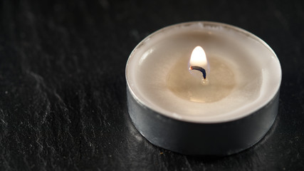 Obraz na płótnie Canvas burning candle on a slate surface