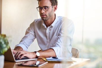 Young businessman working at his dining room table at home