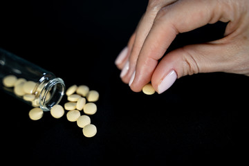 Woman holds small antiviral pill in hand. Drug researched in laboratory speeds up coronavirus recovery in early trials of COVID-19. Active against virus SARS-CoV-2 and ebola disease curation
