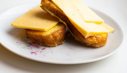fried slices of white bread with cheese on a plate.