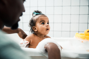 Obraz na płótnie Canvas Father bathing adorable baby in bathroom at home