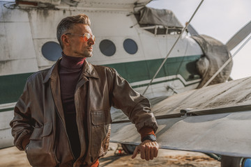 Stylish guy wearing leather jacket near plane © Yakobchuk Olena