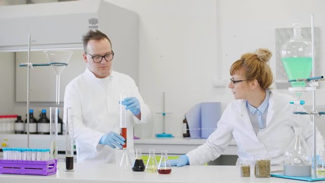 Chemist working with hemp CBD oil and tablet in laboratory