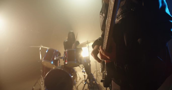 Professional rock band having a concert in club, drummer accompanies the bassists, making cool rock or punk music 4k footage