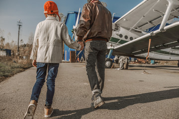 Young father and his son holding hands outdoors
