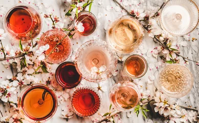 Poster Verschillende tinten rose wijn. Plat leggen van rose wijn in verschillende kleuren in glazen en lentebloesem bloemen over marmeren achtergrond, bovenaanzicht. Wijnwinkel, bar, proeverij, seizoensgebonden wijnkaartconcept © sonyakamoz
