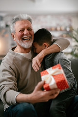 Grandfather giving gift to grandson. 