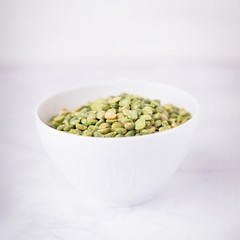 Dry split light green peas in a white cup