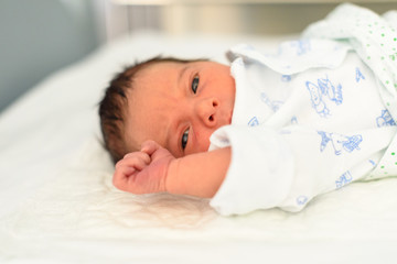 Bebé recién nacido en cuna de hospital