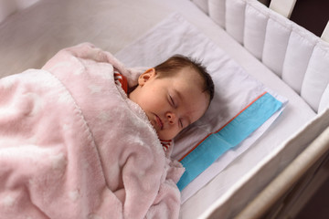 Bebé pequeño dormido en cuna