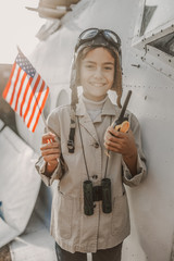 Happy little kid standing with USA flag outdoors