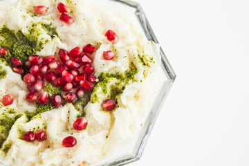 Traditional Turkish Ramadan Milky Dessert;Gullac in glass bowl with pomegranate seeds.Left space for any text message.