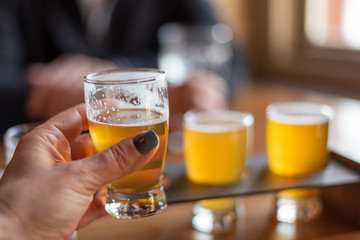 Closeup of a woman holding up a glass of beer