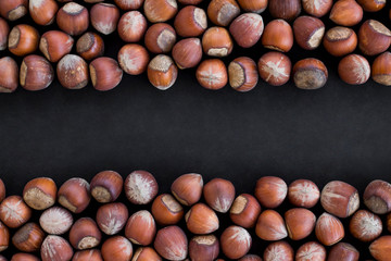 Ripe,shelled hazelnuts on black with copy space.Top view