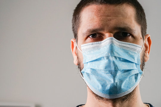 Close Up Portrait Of Caucasian Man Adult Wearing Anti-virus Bacteria Pollution Protective Mask At Home Or Work Head Shot Front View Disease Threatened