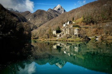 Fototapeta premium paese in montagna tra gli alberi riflesso sul lago