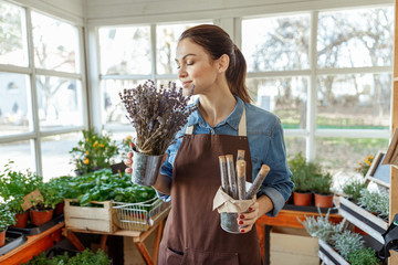 Serene horticulturist with wild flowers standing indoors