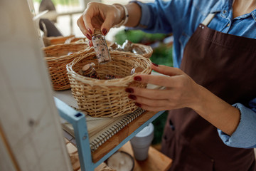 Herbalist taking a small bottle out of a basket