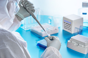 SARS-COV-2 pcr diagnostics kit. Epidemiologist in protective suit, mask and glasses performs pcr...