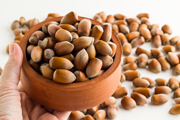 Traditional Turkish Hazelnuts,hand holding a full nuts of casserole pot on blurred background.