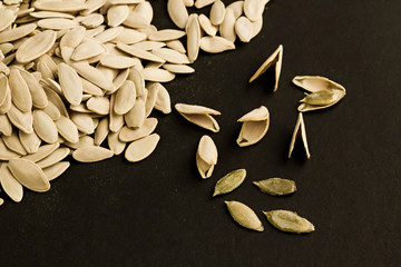 Pumpkin seeds on the black surface with copy space,top view