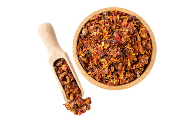 dried tomatoes in wooden bowl and scoop isolated on white background. front view. spices and food ingredients