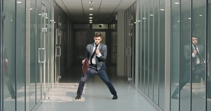 Funny businessman making dance break in office hall, celebrating his victory. Caucasian manager cheering about his achievement - way to success concept 4k