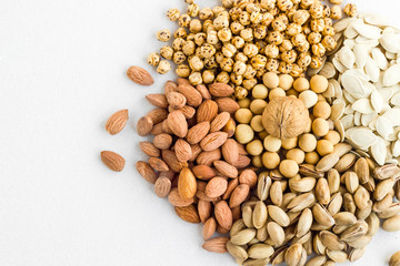 Designed a heap of  shelled nuts varieties on the white fabric surface.Top and half view