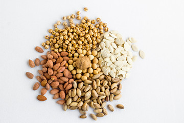 Designed a heap of  shelled nuts varieties on the white fabric surface.Top view