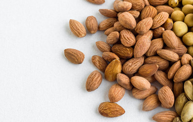 Fresh,crunchy almond nuts on the white fabric surface with copy space