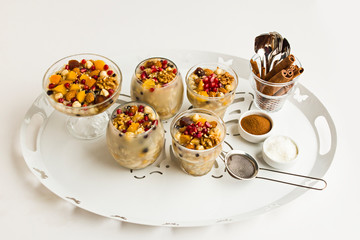 Traditional Dessert,Noah's Pudding or Asure in glasses on metal tray with spoons,cinnamon and coconut powder.Conceptual image of Asure Day.