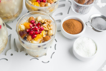 Traditional Dessert,Noah's Pudding or Asure in glasses on white color metal tray with cinnamon and coconut powder.Conceptual image of Asure Day.