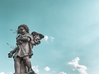 statue of an angel on background of blue sky