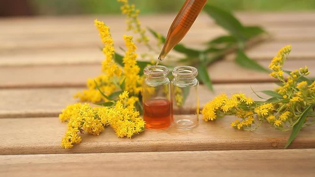 goldenrod essential oil in  beautiful bottle on table
