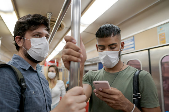 Students And Travelers Using Public Transport For Commuting. Covid-19 And CoronaVirus Concept. People Wearing Masks On The Train.