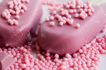 The fourth type in chocolate: Ruby chocolate bar and ice cream on the white porcelain plate.