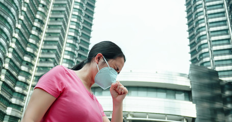 woman coughs and wears mask