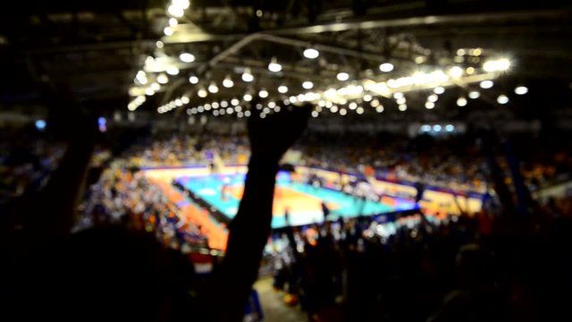 Blurry video of cheering team enjoy in volleyball game in indoor stadium