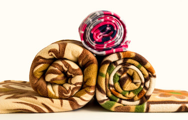 Different size and color fleece blanket rolled on the white background
